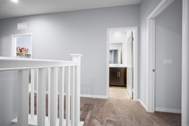 corridor featuring light colored carpet