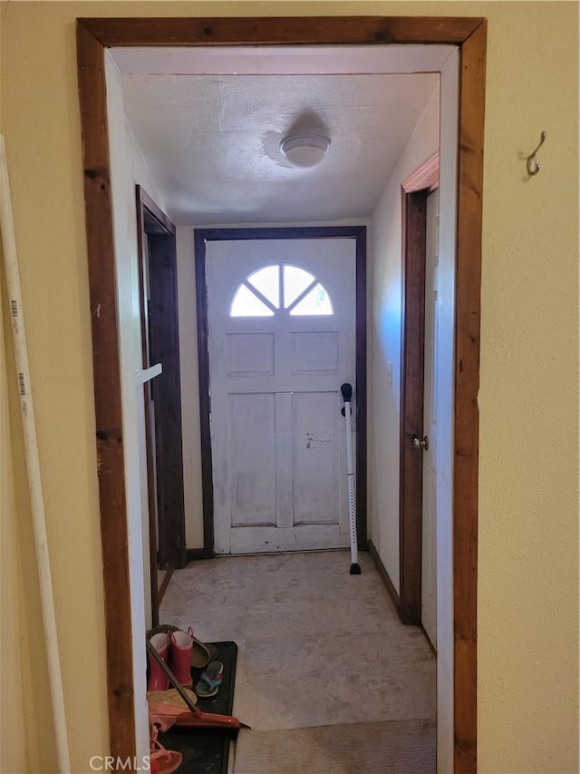 doorway to outside with a textured ceiling