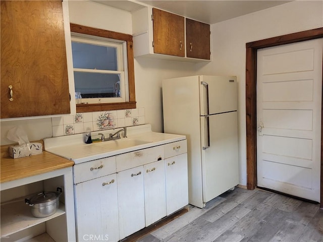 300 Bald Rock Rd, Berry Creek, CA 95916 - kitchen with freestanding refrigerator, light countertops, backsplash, light wood-style floors, and white cabinets