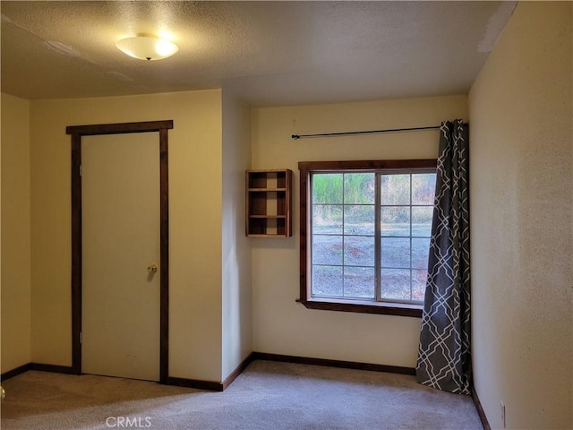 unfurnished bedroom featuring light carpet and a textured ceiling