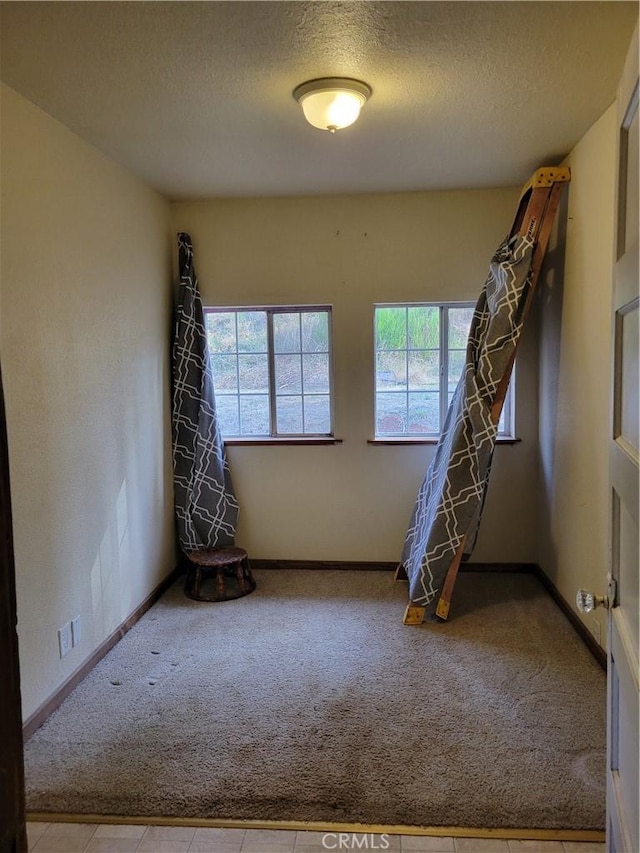 carpeted spare room with a textured ceiling