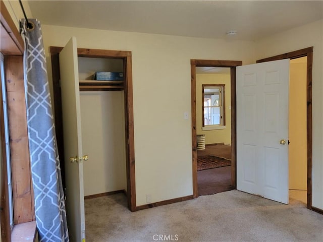 unfurnished bedroom with a closet and light colored carpet