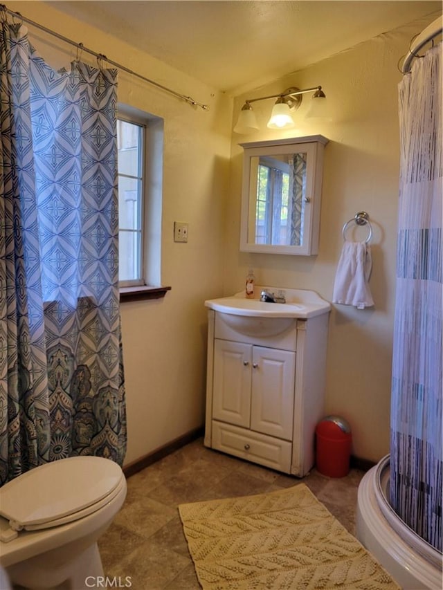 bathroom with curtained shower, vanity, and toilet