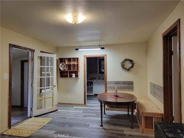 dining space featuring wood-type flooring and a textured ceiling