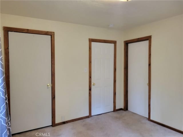 unfurnished bedroom with light colored carpet and a closet