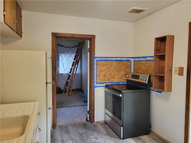 kitchen with sink, light hardwood / wood-style floors, white fridge, and electric stove