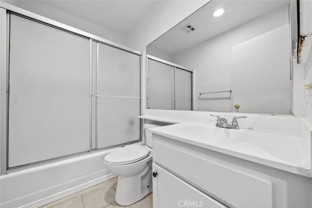 full bathroom with bath / shower combo with glass door, toilet, vanity, and tile patterned flooring