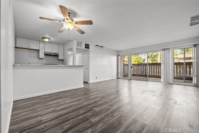 unfurnished living room featuring ceiling fan and dark hardwood / wood-style floors