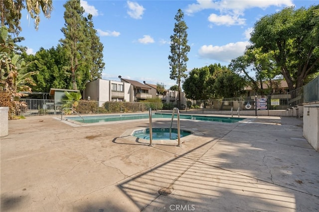 view of pool featuring a hot tub and a patio