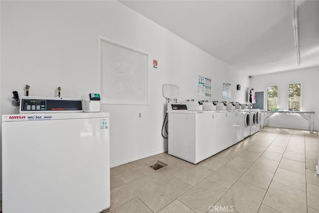 laundry area featuring light tile patterned floors and washing machine and dryer