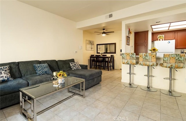 living room with ceiling fan and light tile patterned floors