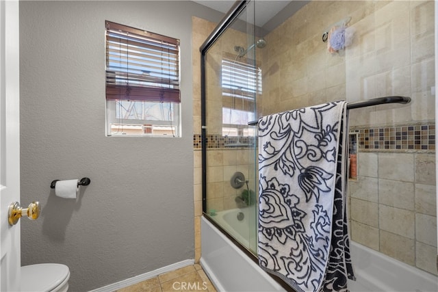 bathroom featuring tile patterned flooring, tiled shower / bath combo, and toilet