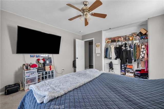 carpeted bedroom with a textured ceiling, ceiling fan, and a closet