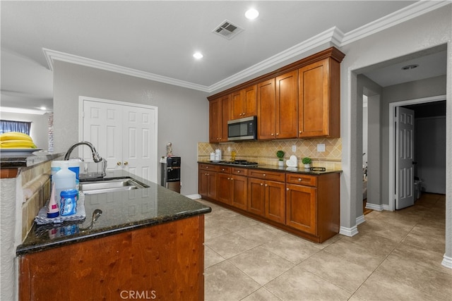 kitchen featuring light tile patterned floors, ornamental molding, sink, appliances with stainless steel finishes, and dark stone counters