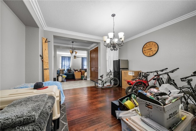 bedroom featuring wood-type flooring, a chandelier, a textured ceiling, and crown molding