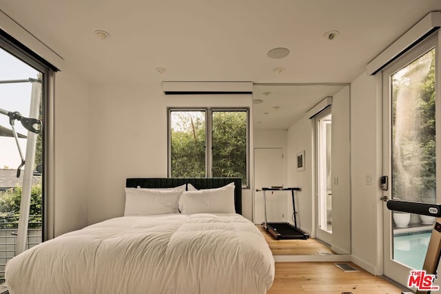 bedroom with light hardwood / wood-style flooring and access to outside