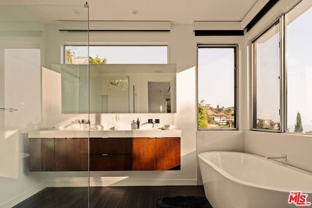 bathroom with wood-type flooring, vanity, and shower with separate bathtub