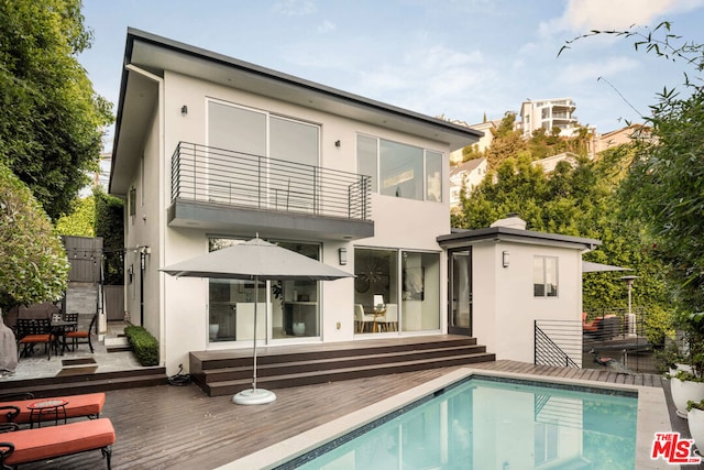 back of house featuring a swimming pool side deck