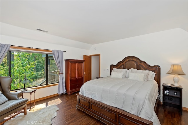 bedroom with vaulted ceiling and dark wood-type flooring