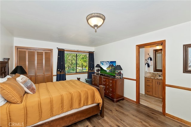 bedroom featuring connected bathroom, a closet, and dark hardwood / wood-style flooring