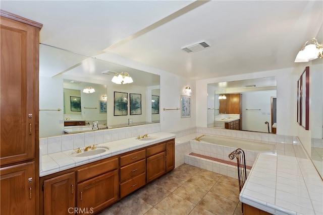 bathroom featuring vanity, tiled bath, tile patterned flooring, and a notable chandelier