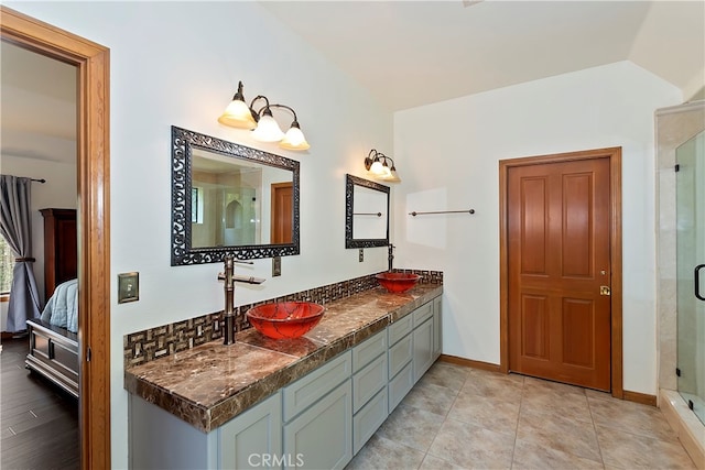 bathroom with vanity, lofted ceiling, an enclosed shower, and tile patterned floors