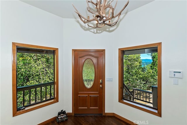 interior space featuring an inviting chandelier, dark wood-type flooring, and plenty of natural light