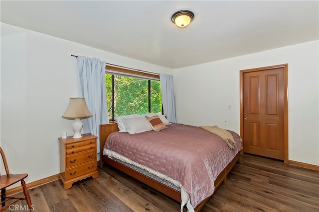 bedroom with dark hardwood / wood-style flooring