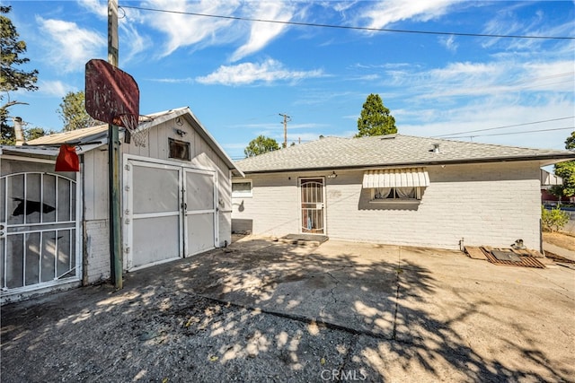 view of front of house with a patio and a storage unit