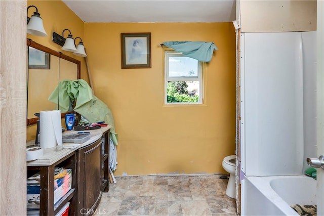 bathroom with vanity, a bathtub, and toilet