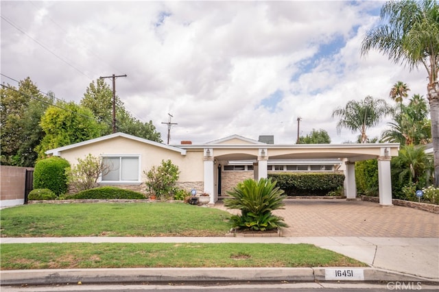 view of front of house with a front yard, a garage, and a carport