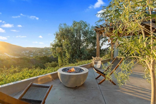 view of patio / terrace featuring a mountain view and a fire pit