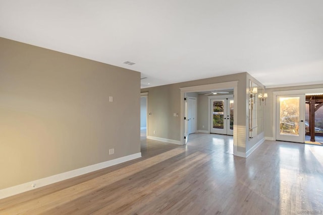 spare room featuring french doors and hardwood / wood-style flooring