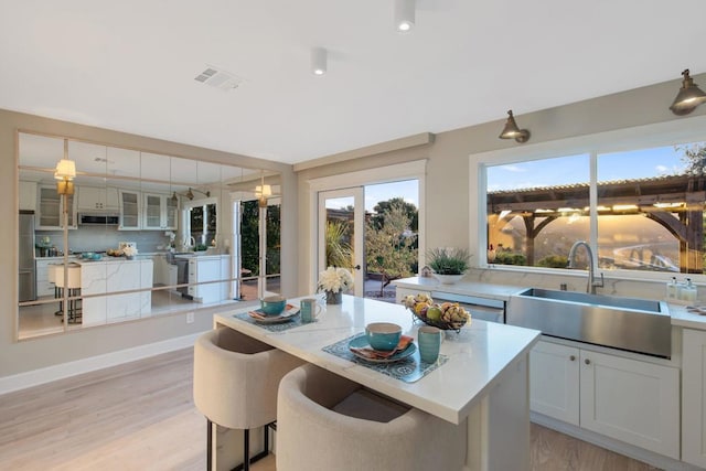 kitchen featuring white cabinets, light hardwood / wood-style floors, sink, and stainless steel appliances