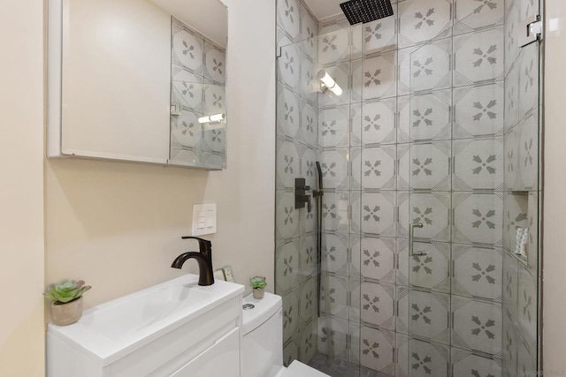 bathroom featuring a tile shower, vanity, and toilet