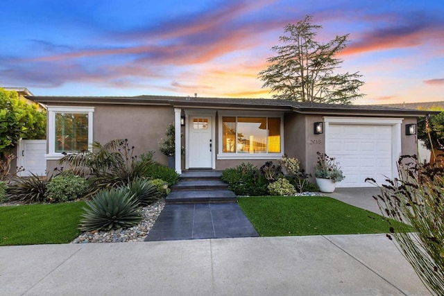 view of front of home featuring a garage and a lawn