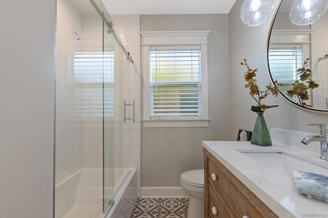 full bathroom with vanity, tile patterned flooring, a healthy amount of sunlight, and toilet