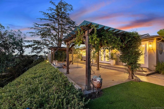 yard at dusk featuring a patio and a pergola