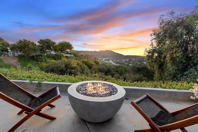 patio terrace at dusk with a mountain view and an outdoor fire pit