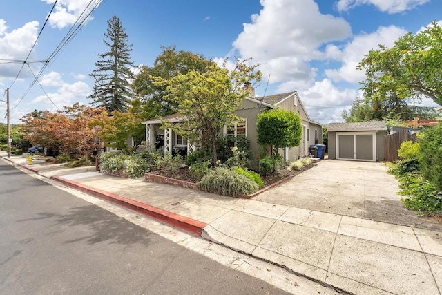 view of property hidden behind natural elements with a garage and an outbuilding