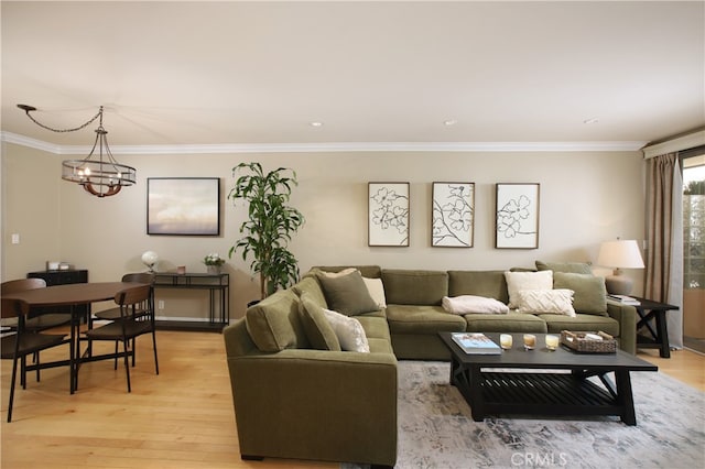 living room with a notable chandelier, light hardwood / wood-style flooring, and ornamental molding