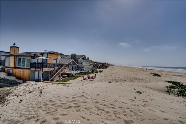 view of yard featuring a water view and a view of the beach