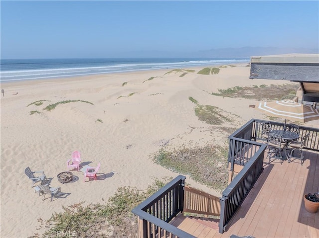 view of water feature featuring a beach view and a fire pit