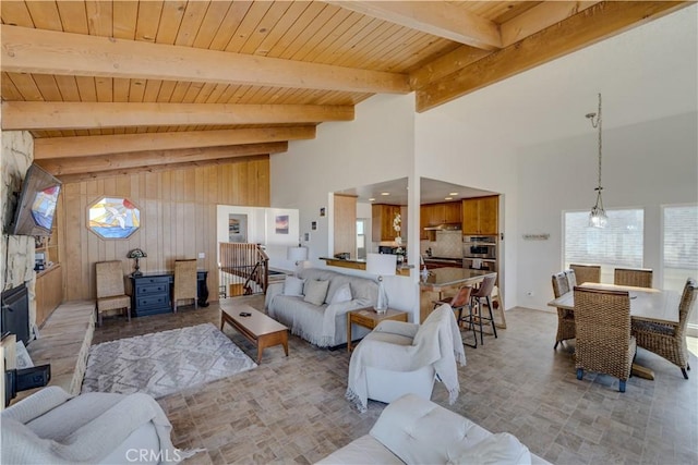 living room with beamed ceiling, wood ceiling, and wood walls