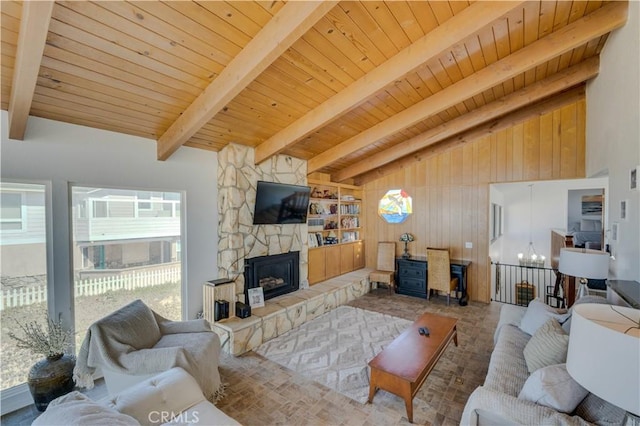 living room featuring wood ceiling, a stone fireplace, lofted ceiling with beams, and wood walls