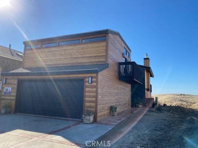 view of home's exterior featuring a garage and a balcony