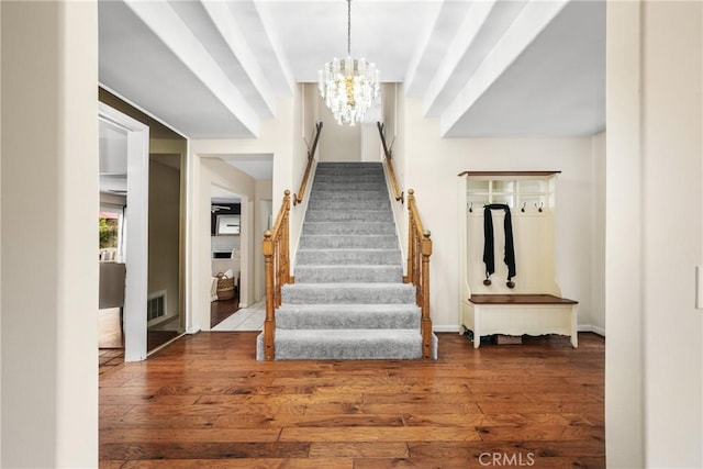 staircase featuring a chandelier and hardwood / wood-style flooring