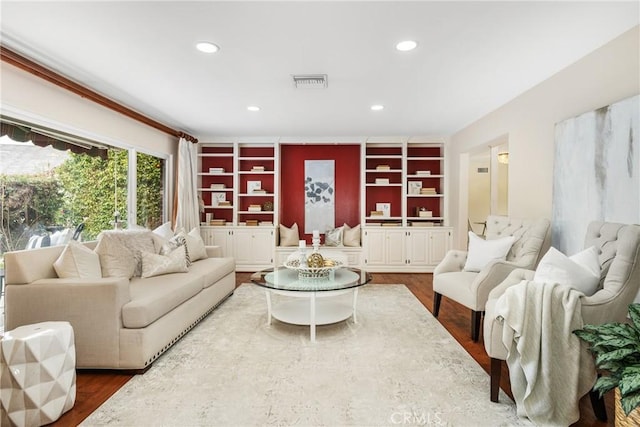 living room with built in features and hardwood / wood-style flooring