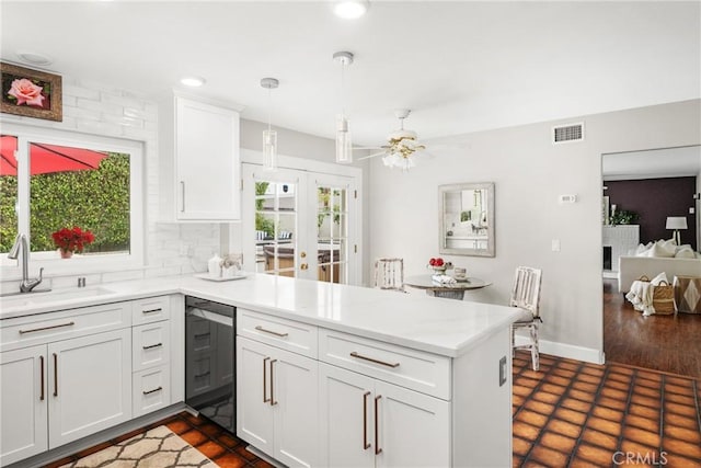 kitchen featuring pendant lighting, white cabinets, and kitchen peninsula