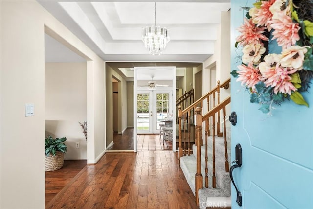 foyer featuring dark hardwood / wood-style flooring, ceiling fan with notable chandelier, and french doors